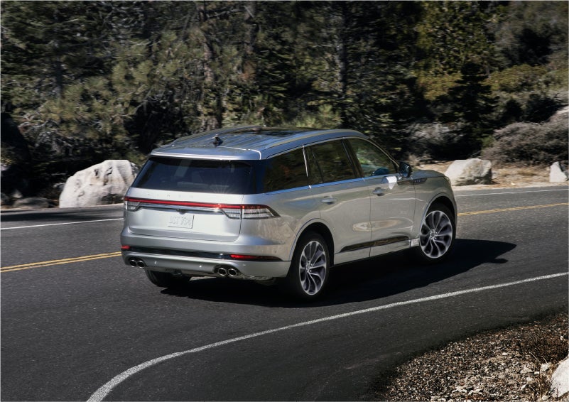 A 2023 Lincoln Aviator® Grand Touring model is shown being driven on a tight turn of a mountain road | Korum Lincoln in Puyallup WA