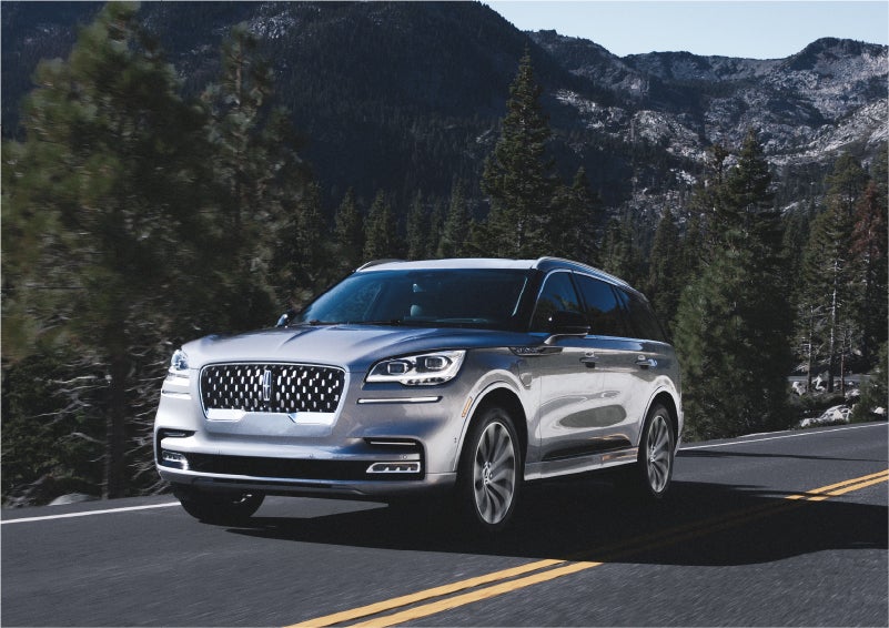 A 2023 Lincoln Aviator® Grand Touring SUV being driven on a winding road to demonstrate the capabilities of all-wheel drive | Korum Lincoln in Puyallup WA
