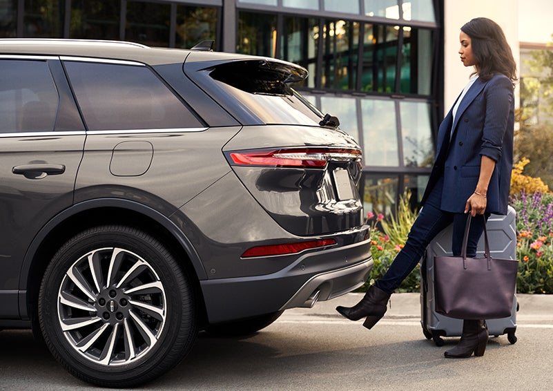 A woman with her hands full uses her foot to activate the available hands-free liftgate. | Korum Lincoln in Puyallup WA