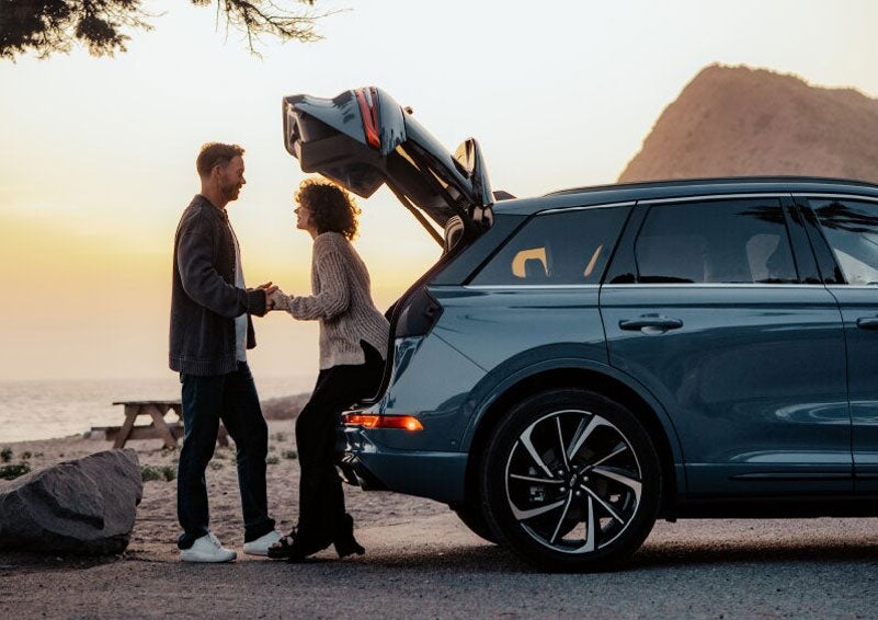 A couple share a moment together outside a 2025 Lincoln Corsair® SUV near the open liftgate. | Korum Lincoln in Puyallup WA