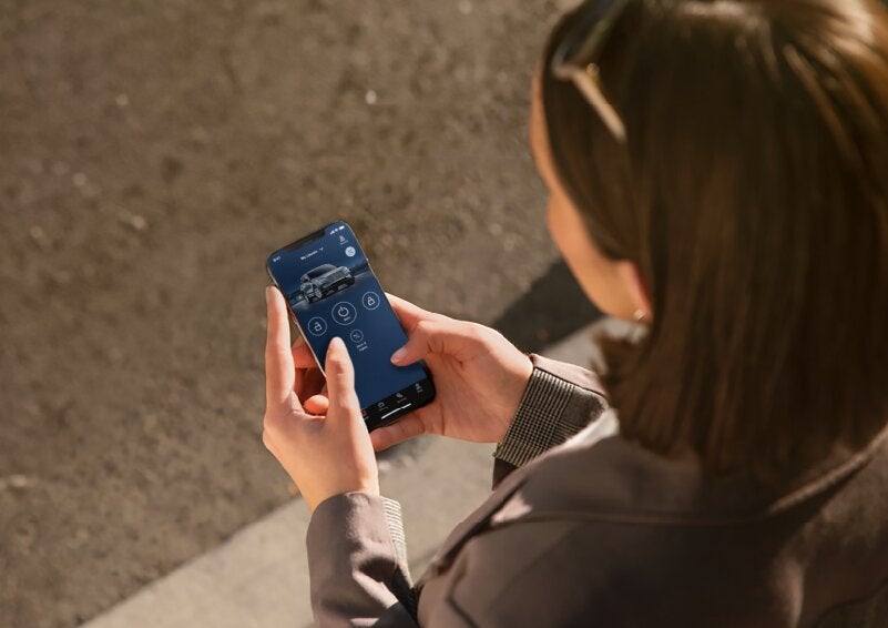 A person is shown interacting with a smartphone to connect to a Lincoln vehicle via the Lincoln Way® App. | Korum Lincoln in Puyallup WA