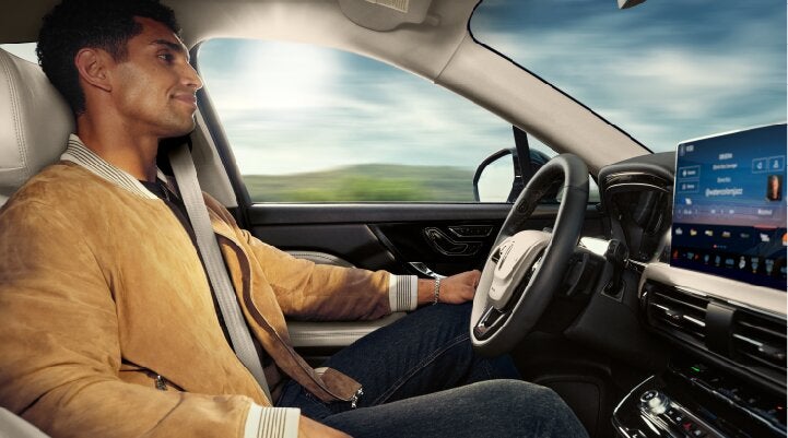 A person is shown using Lincoln BlueCruise hands-free highway driving technology on a divided highway called a Hands-Free Blue Zone. | Korum Lincoln in Puyallup WA