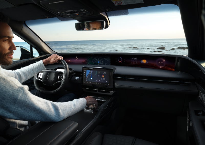 A driver of a parked 2025 Lincoln Nautilus® SUV takes a relaxing moment at a seaside overlook while inside his Nautilus. | Korum Lincoln in Puyallup WA