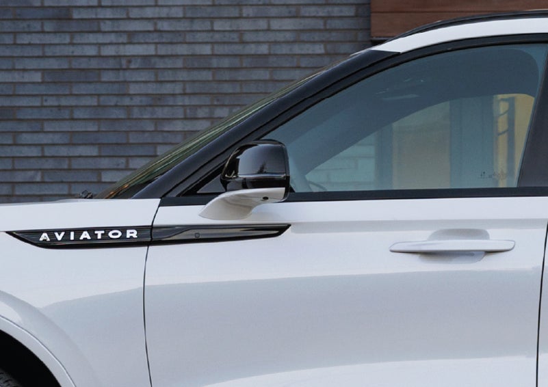 The driver’s side door and fender badging of a white 2026 Lincoln Aviator® SUV are showcased. | Korum Lincoln in Puyallup WA