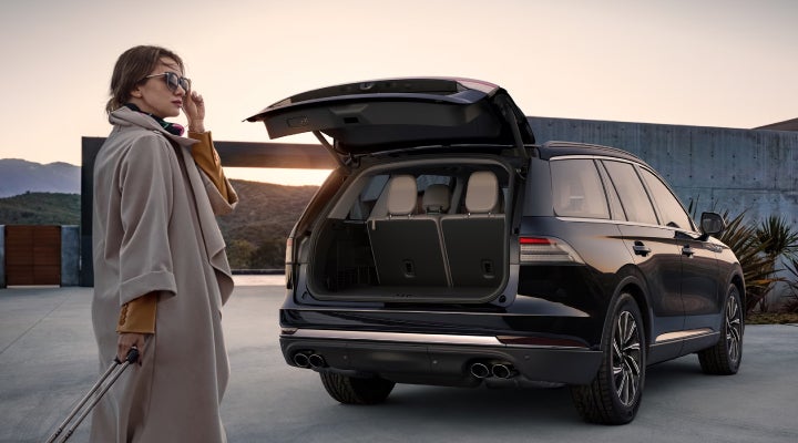 A woman approaches a 2026 Lincoln Aviator® SUV with its rear liftgate open. | Korum Lincoln in Puyallup WA