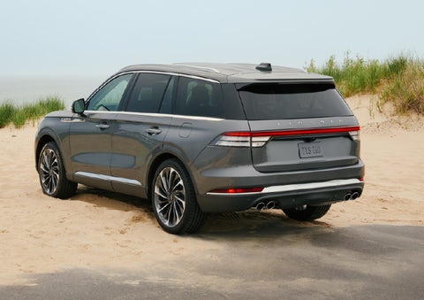 A 2027 Lincoln Aviator® SUV is parked next to sand dunes. | Korum Lincoln in Puyallup WA