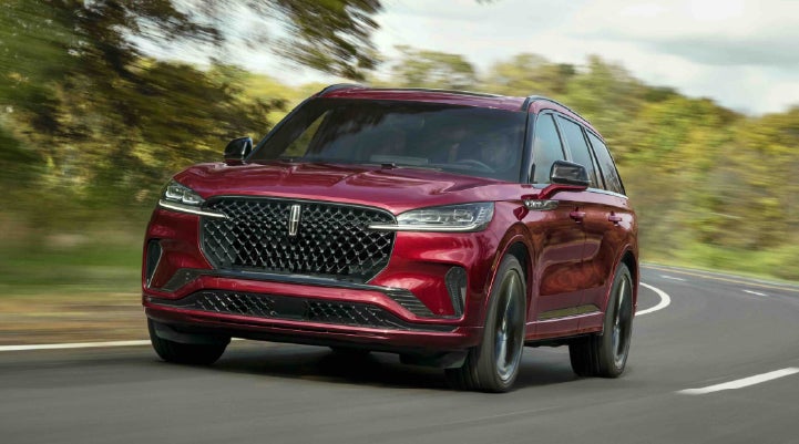 A 2027 Lincoln Aviator® SUV is being driven on a country road | Korum Lincoln in Puyallup WA